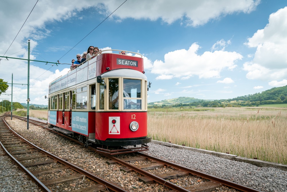 Picture of a red tram going throught the country side